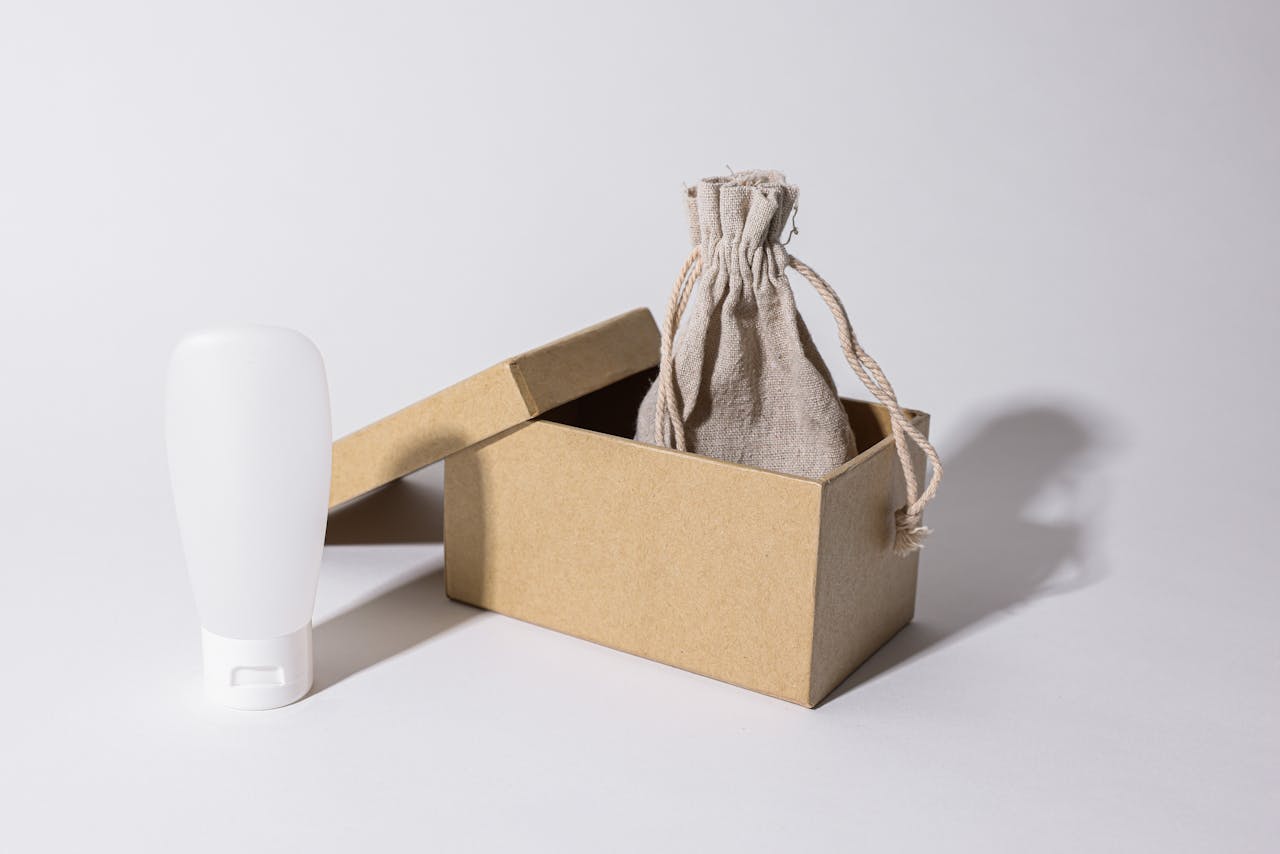 Avaleht Minimalist photo of eco-friendly packaging with a cardboard box, pouch, and white plastic bottle.